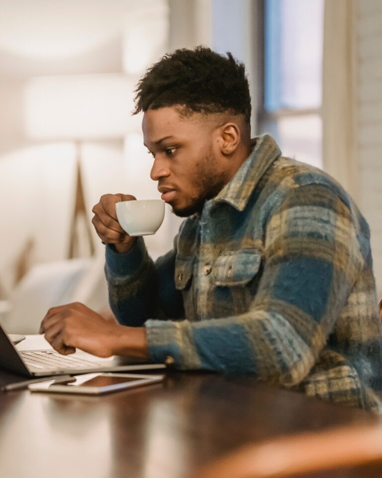 Man reading the Fearless Homebuyers blog on his computer while holding a cup of tea.