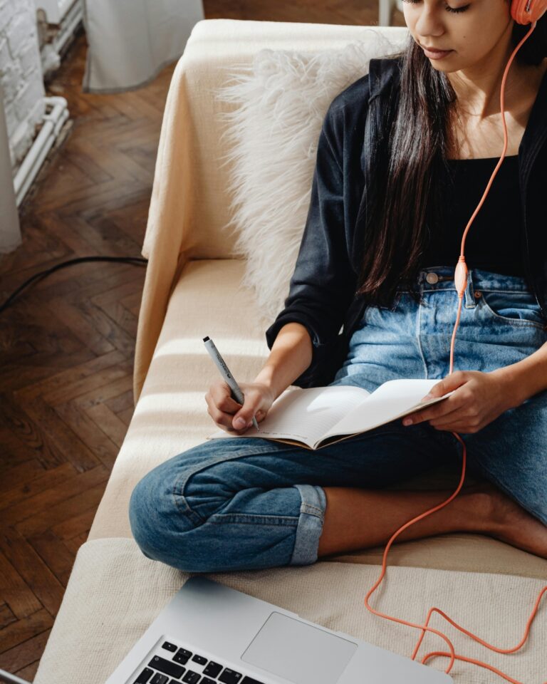 Woman studying on her computer and taking notes while completing the Fearless Homebuyers online course.