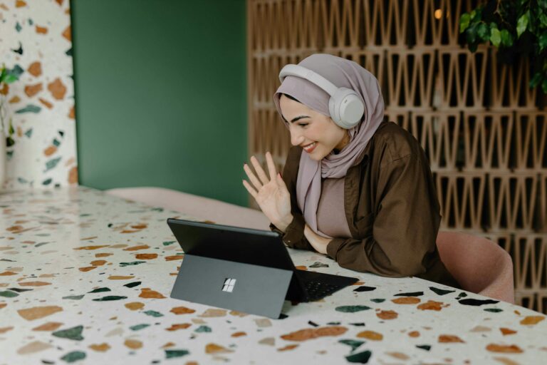 Woman sitting at a table using a laptop while taking the Fearless Homebuyer online course to build money confidence and prepare for homeownership